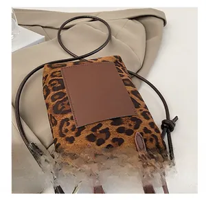 Detail of leopard print bucket bag featuring brown leather patch and knotted rope strap