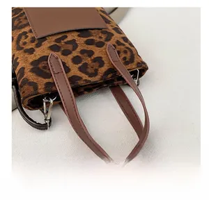 Close-up of leopard print bucket bag featuring brown PU leather handle and silver metal hooks