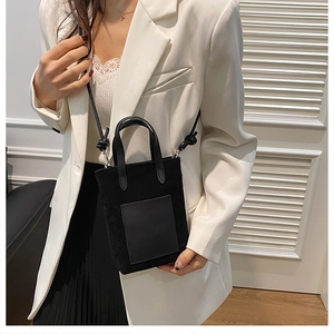 Mini black suede tote bag with leather straps styled with a white blazer and skirt