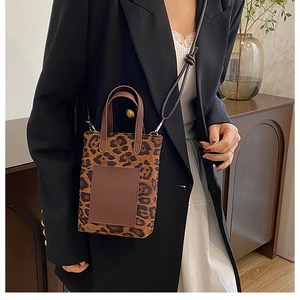 Chic leopard print mini bucket bag with brown leather handles styled on a model