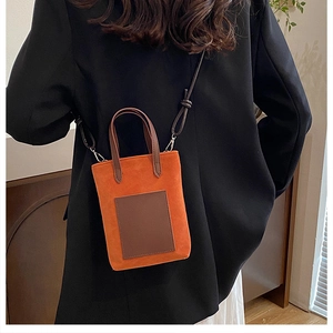 Chic orange and brown contrast crossbody bag shown on a model in a black blazer
