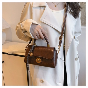 Sac à main rétro en cuir marron avec fermoir pivotant vintage et détail de foulard rayé