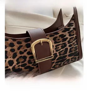 Gros plan sur un sac léopard avec boucle en métal doré et finitions en cuir élégantes