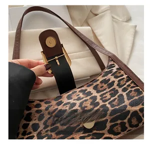 Détail du fermoir magnétique doré et de la texture cuir à motif léopard sur le sac