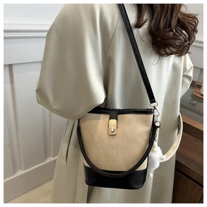 Detail of color-block bucket bag showing canvas texture and golden twist-lock closure