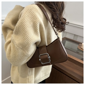 Détail du sac à bandoulière en cuir marron rétro avec boucle en métal argenté brillant