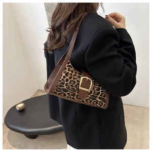 Detail der modischen Schultertasche mit Leopardenmuster, braunem Rand und Goldschnalle