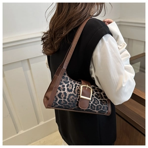 Detail of the leopard print shoulder bag featuring a gold buckle and brown leather strap