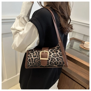 Detail der Schultertasche mit Leopardenmuster, Goldschnalle und braunem Lederbesatz