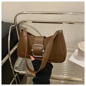 Detail of a brown leather crescent bag featuring a large silver square metal buckle