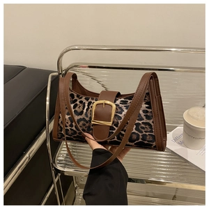 Detail der Handtasche mit Leopardenmuster, braunem Lederbesatz und goldener Schnalle