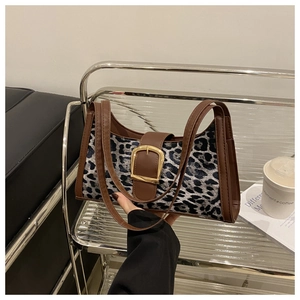 Detail der Tasche mit Leopardenmuster, goldener Schnalle und braunem Lederbesatz