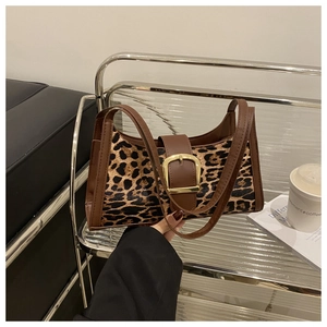 Detail der Leoparden-Achseltasche mit großer goldener Schnalle und braunem Lederbesatz