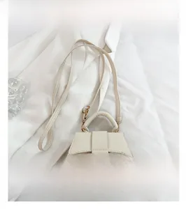 Détail du mini sac blanc motif litchi avec sangle décorative et fermeture à rabat
