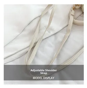 Détail de la bandoulière réglable en cuir crème avec boucle dorée et couture