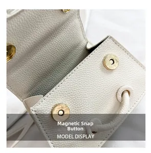 Détail du cuir grainé blanc et de la fermeture sécurisée par double bouton aimanté