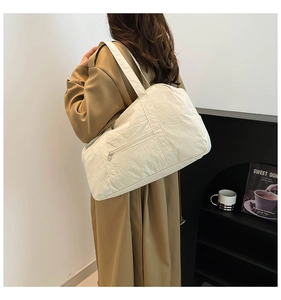 Detail of off-white large capacity tote bag featuring nylon texture and zip pocket