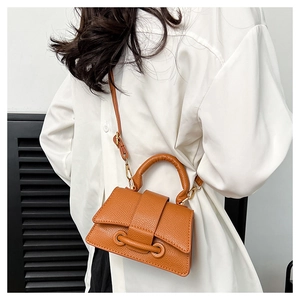 Vue détaillée du mini sac bandoulière marron orangé avec texture cuir grainé et rabat chic