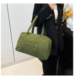 Detailed view of an olive green large capacity nylon tote bag worn on shoulder