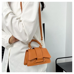 Vue latérale d'un sac bandoulière en cuir marron avec détail de ceinture sur un mannequin