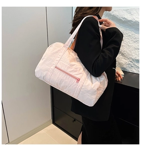Close-up of lightweight pale pink tote bag worn by a model in a minimalist setting