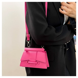 Détail du mini sac bandoulière fuchsia avec texture cuir litchi et boucle rabat