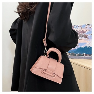 Vue arrière d'un mini sac bandoulière rose grainé porté avec un blazer noir chic