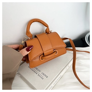 Détail d'un mini sac à main marron à motif litchi avec boucle de ceinture et fine bandoulière