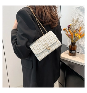 Sac bandoulière en tweed blanc avec chaîne dorée et fermoir sur un mannequin femme