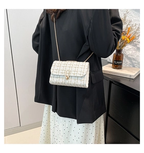 Détail du sac bandoulière en tweed avec chaîne dorée et fermoir métallique ovale