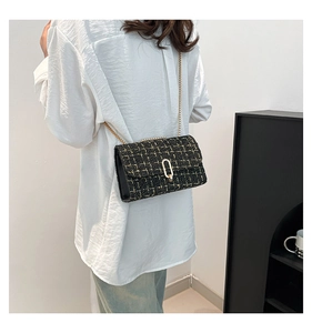 Sac bandoulière en tweed noir et doré, texture luxueuse et coupe élégante pour femmes chic