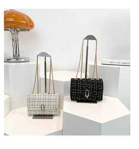 Detail of elegant tweed plaid chain bags with gold metal locks and weaving textures