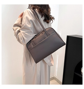 Grand sac cabas en similicuir taupe foncé porté par un mannequin en trench beige