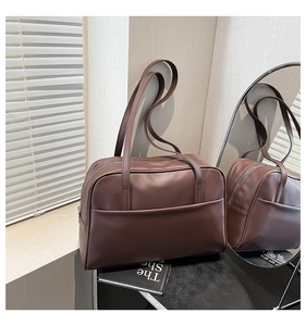 Détail d'un grand sac cabas en similicuir marron avec longues anses et poche frontale externe