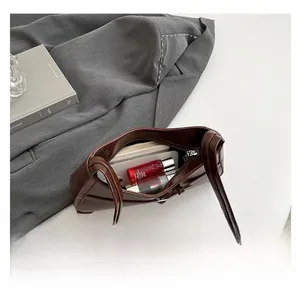 Internal view of the brown leather shoulder bag showing storage for phone and makeup