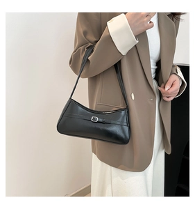 Chic black faux leather underarm bag styled with a khaki blazer on model