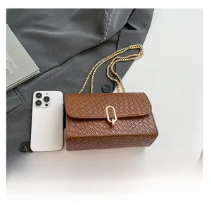 Detailed shot of dark brown woven texture handbag with golden chain strap and rotary lock