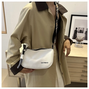 Gros plan du sac seau blanc avec bandoulière géométrique et nœud décoratif