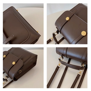 Detail of vintage dark brown faux leather backpack with gold metal hardware and flap