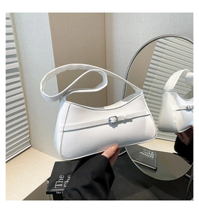 Detail of white baguette underarm bag featuring decorative silver buckle and PU leather texture