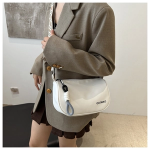 Détail du sac à bandoulière en nylon blanc avec pampille en corde et logo imprimé