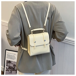 Minimalist cream white mini backpack on model showing clean aesthetic and PU leather texture