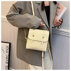 Close-up of cream white PU leather bag showing matte finish and gold stud details