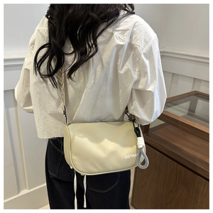 Vue de dos d'un sac bandoulière beige chic avec sangle jacquard porté par un mannequin