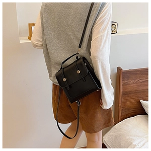 Detailed view of a vintage black square backpack with gold buckle and leather straps