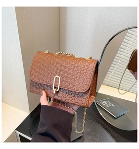 Vue détaillée du sac à bandoulière marron tressé avec fermoir doré élégant en métal