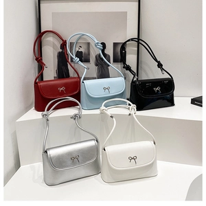 Five small flap shoulder bags with metal bow accents in various elegant colors