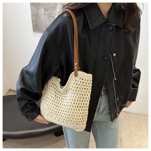Detail of crochet tote bag featuring cream cotton weave and brown leather strap with rivets