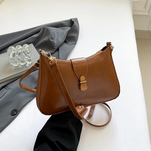 Retro caramel brown leather underarm bag with gold metal buckle and adjustable strap