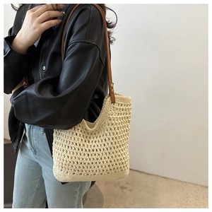 Detail of hand-crocheted cream tote bag featuring hollow mesh texture and brown leather strap